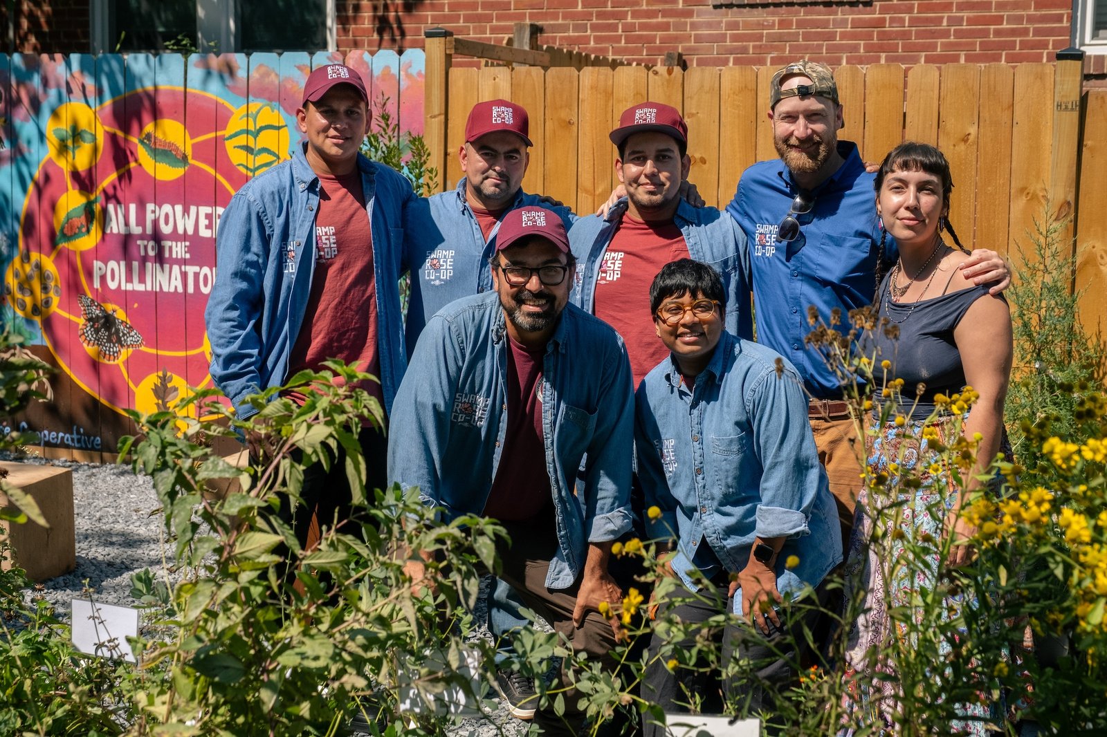The Swamp Rose team and Transverse Co-op worker-owner Camila smile together in the native plant nursery.